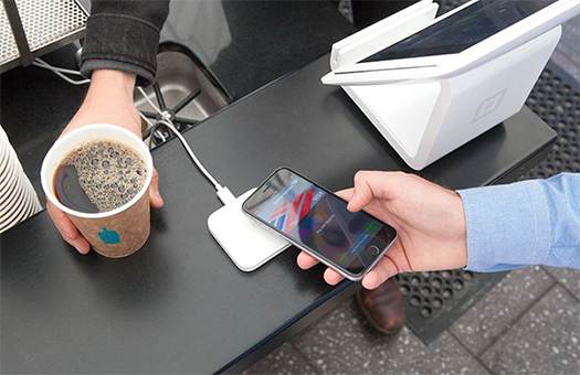 This is a photograph of Apple Pay being used to purchase a cup of coffee.