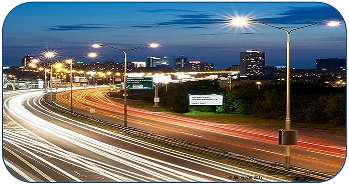 A time-lapse photo of a lighted highway with vehicular traffic.