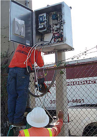 A photo shows an electrician working on a roadside lighting cabinet.