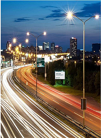 A photo shows a busy highway at dusk with streetlights turned on.