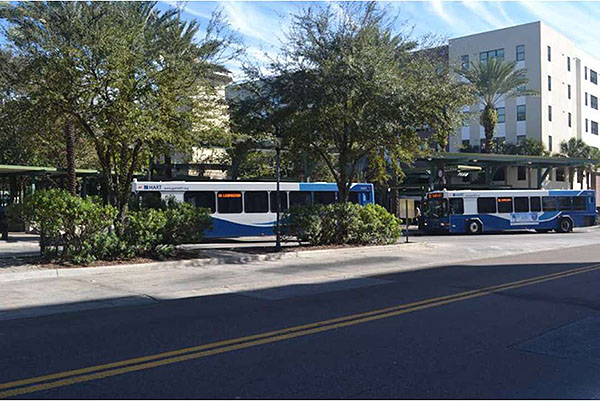 Authors relevant description: Photo of a transit stop with approaching buses