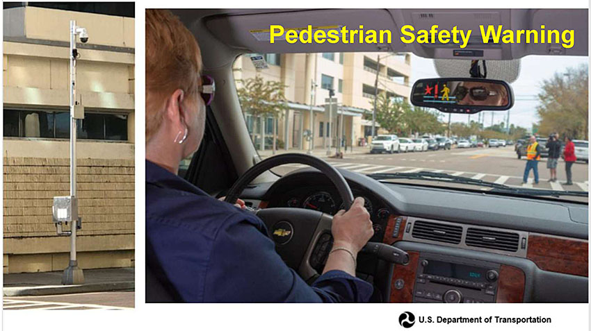 The slide shows a women driver driving a car at the intersection where three pedestrians are crossing in crosswalk immediately in front of the vehicle. That information generates a warning message, which is displayed in the mirror with a Ped walking symbol. This completes the demonstration of Pedestrian Safety Warning.