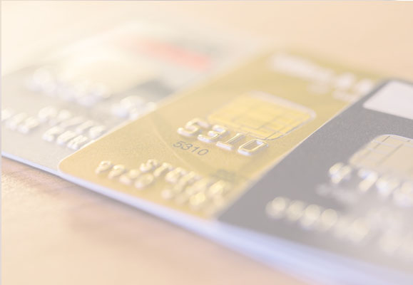 Background image - faded photo of a group of bankcards placed on top of each other with only the left side of each card visible.
