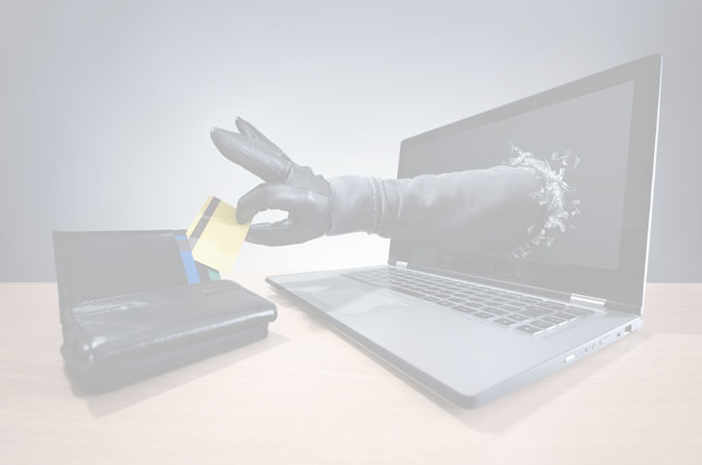 Background image - faded photo of a laptop computer sitting on top of a table to the right of a wallet. There is a hand and a portion of an arm reaching out from a hole in the display of the computer to the wallet and pulling out a bankcard.