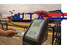 A photo of a card validator sitting on a train station platform. In the background, there is a commuter train and stair rails. Superimposed on the photo is the logo of the Utah Transit Authority, with the letters UTA and a red, white and blue symbol.
