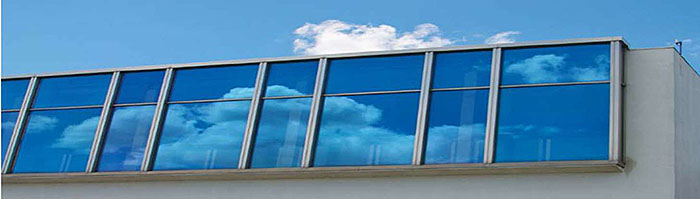 A photo at the bottom of the slide of windows with clouds reflected in them.