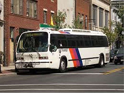 An image of a NJ Transit bus in an urban area.