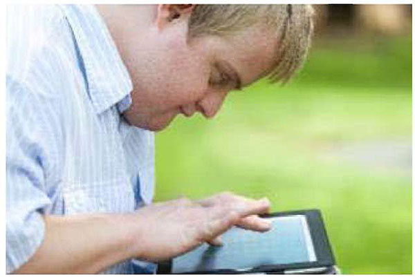This slide contains a picture of a person with cognitive issues holding a tablet computer.