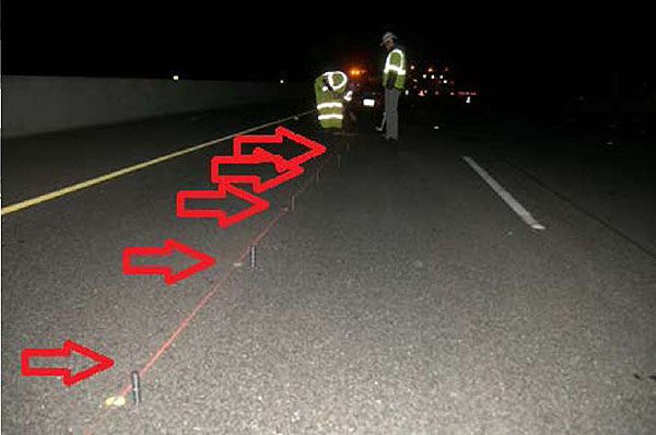 Photo shows the magnets being installed in holes drilled in the pavement at night.