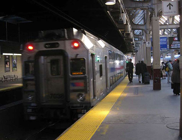 This slide shows a photo of a NJ TRANSIT commuter train at a station platform.