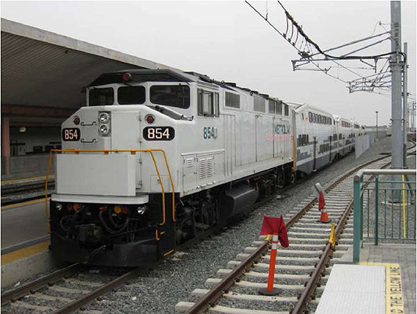 This slide shows a Metrolink commuter train with a locomotive and three cars at a platform.