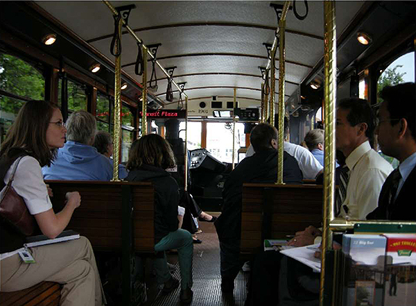 A photo of the interior of a bus with people on the bus. The photo is on the right-hand side of the bottom of the slide.