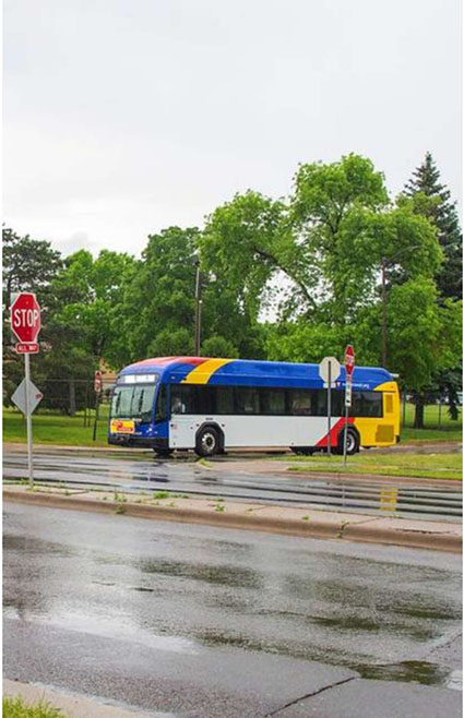 This slide is entitled, “Metro Transit”. There is a graphic on the left-hand side of a transit bus stopped at a stop sign in the rain.
