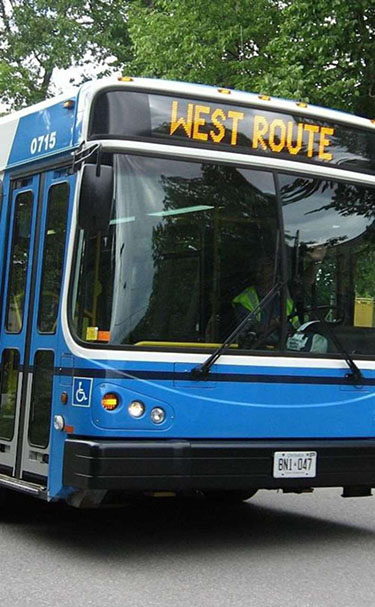 On the left-hand side of the slide, there is a picture of a transit bus. The words “West Route” displayed on the route indicator on the front of the bus.