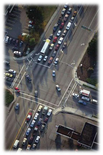 There is an aerial photo of a four way intersection with vehicles queued and turning on the right-hand side of the slide.