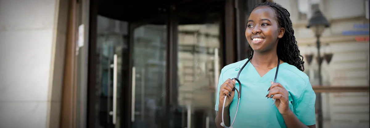 A nurse standing outside a building