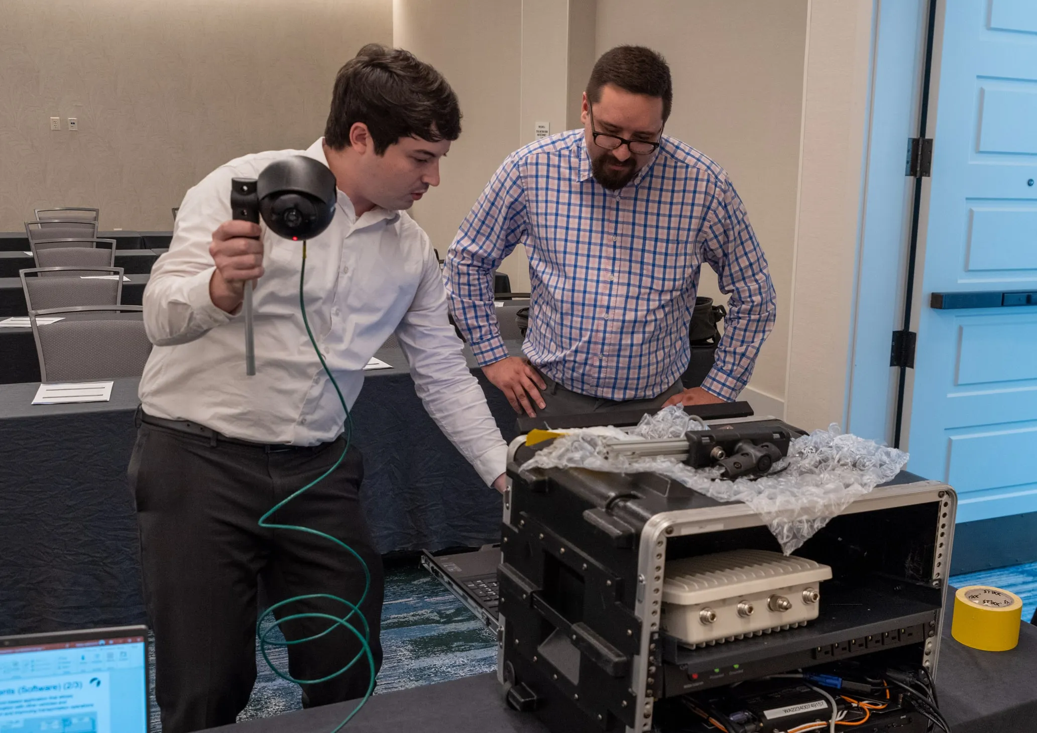 Two people standing over CAVe-in-a-box