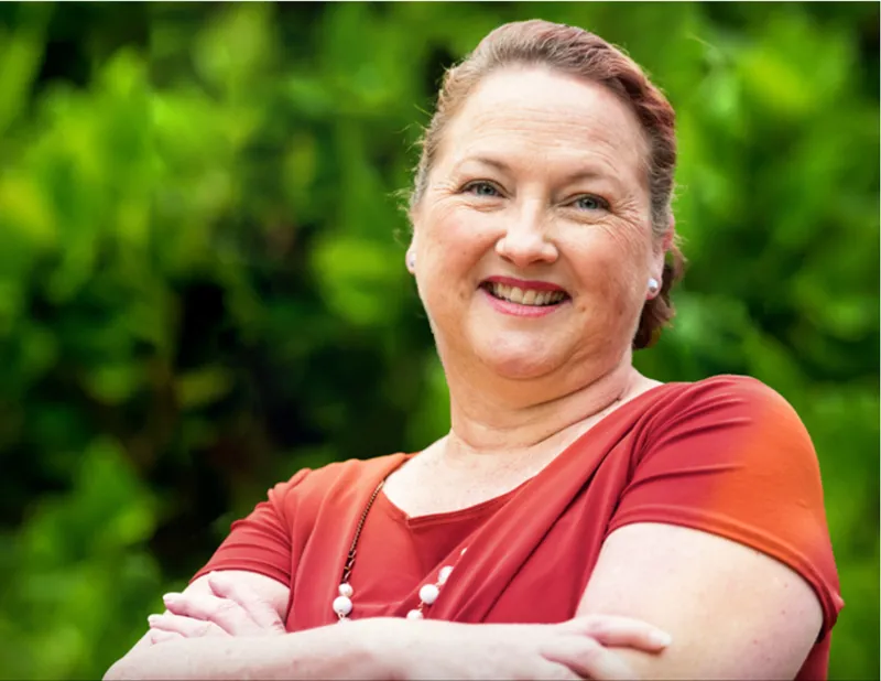 A smiling woman with arms folded