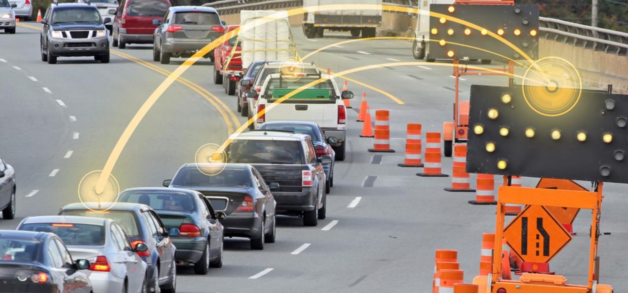 Traffic on a road in a construction zone with lines going from construction work signs to individual vehicles