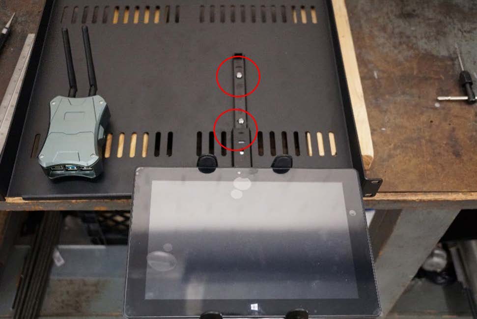 This photo shows the proper mounting of a tablet on a component shelf. The locations of the 10-24 screws are circled.