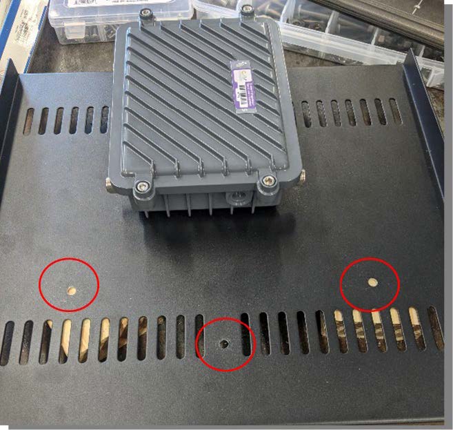 This photo demonstrates where to place the holes to mount the traffic controller on a component shelf. The three holes are circled in the photo.