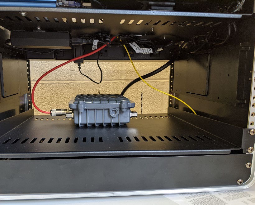 This photo shows the roadside unit (RSU) mounted on the lower shelf of Connected and Automated Vehicle education (CAVe)-in-a-box.
