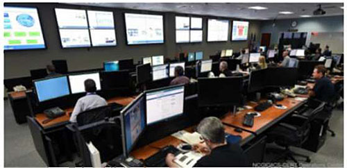 This slide has a screen shot image on the right upper corner of the NCCIC Systems Operation Center, with people sitting at monitors in front of a video wall.